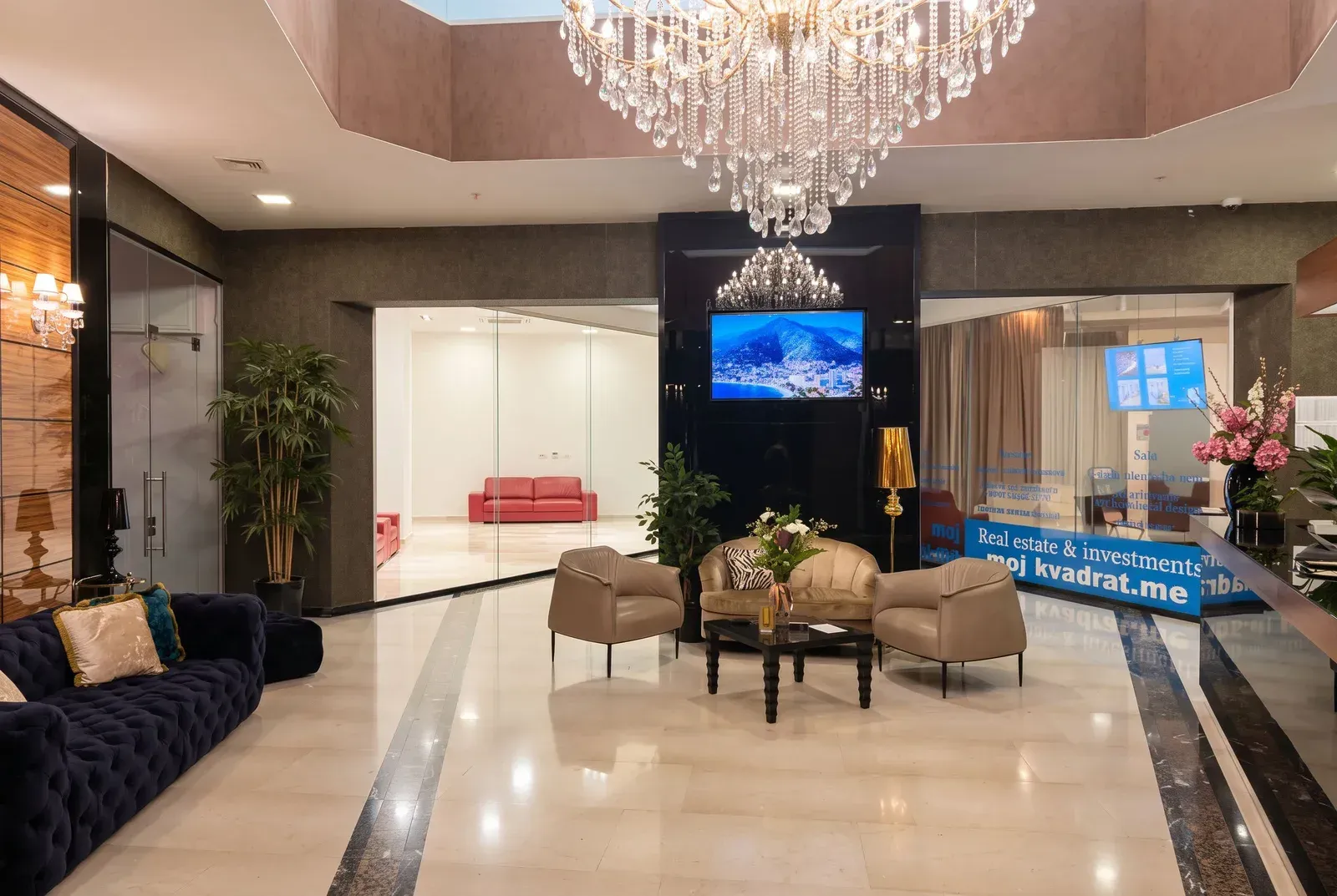 Modern and spacious lobby with seating furniture and a large chandelier.