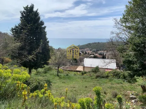 Pogled na plac sa zelenilom, okolnim objektima i morem u pozadini. - image 6
