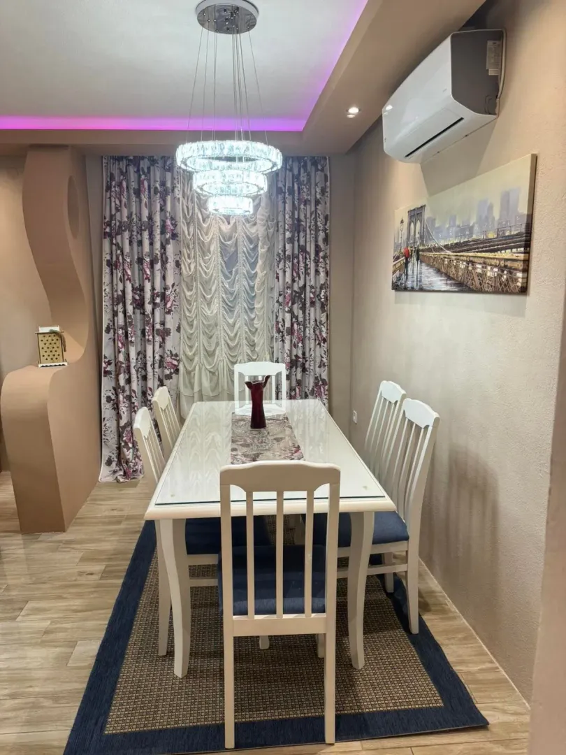 Dining room with table, chairs, and chandelier.
