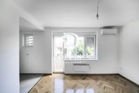 Prazna soba sa parketom, klima uređajem i izlazom na terasu. - image 5