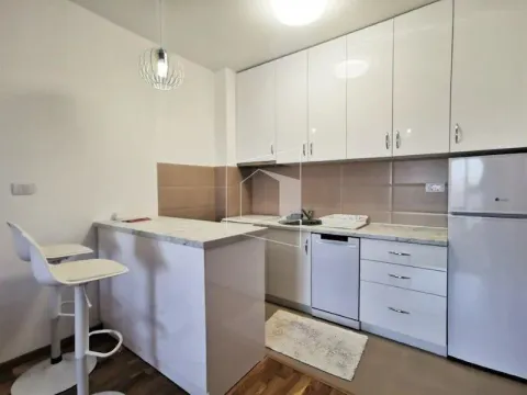 Modern kitchen with white cabinetry and a breakfast bar. - image 4