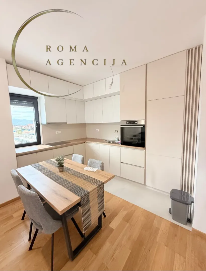 Modern kitchen with dining table and built-in appliances.