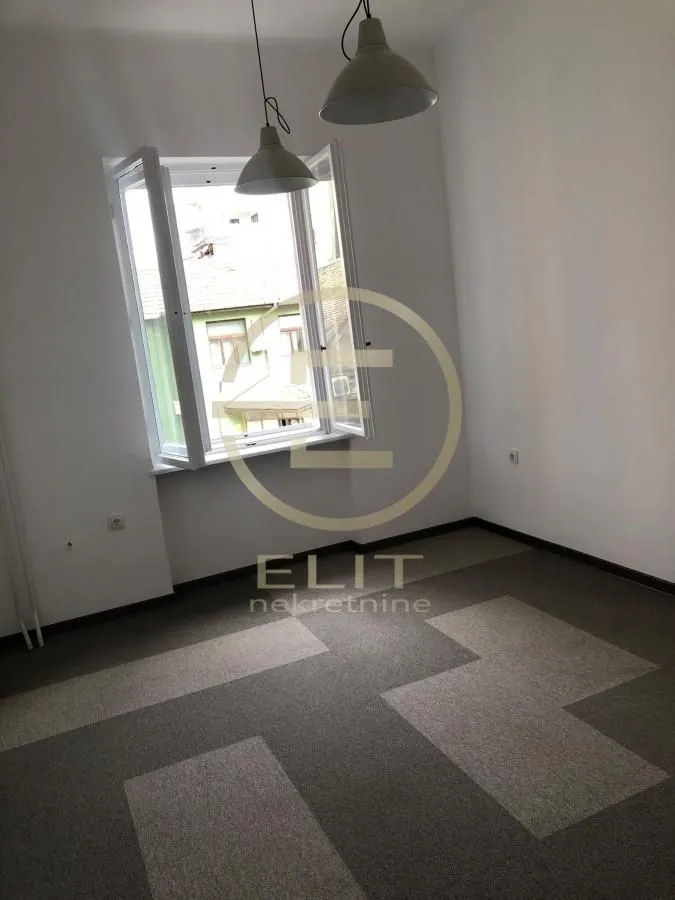 Empty room with a window and ceiling lights.