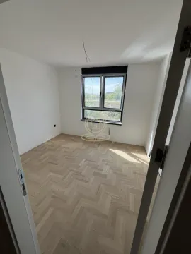 Prazna soba sa parketom i prozorom, gledana sa vrata. - image 4