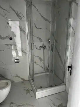 Newly equipped bathroom with a shower cabin and marble tiles. - image 8