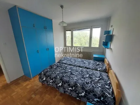 Spavaća soba sa dva kreveta i plavim ormanom. - image 8