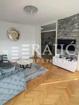 Living room with sofa, TV and a view of the kitchen. - image 2