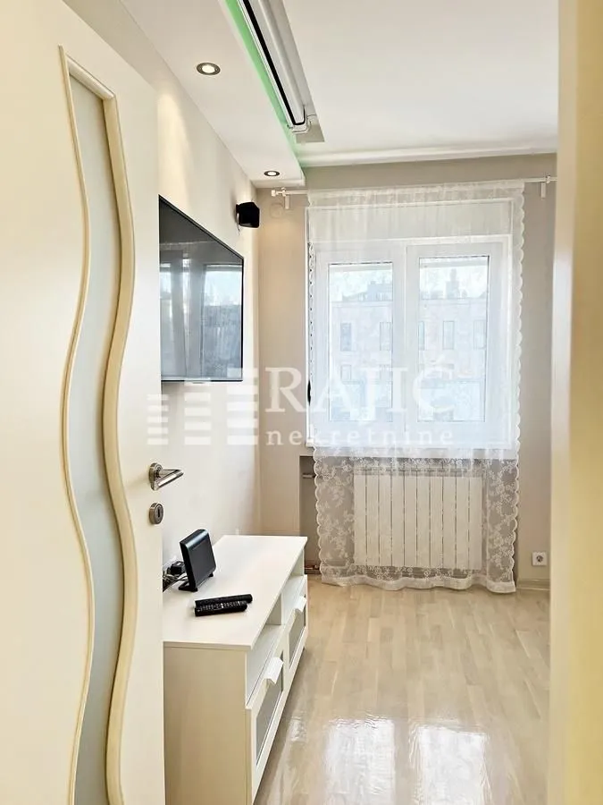Small living room with a TV and a TV unit, photographed from the doorway.