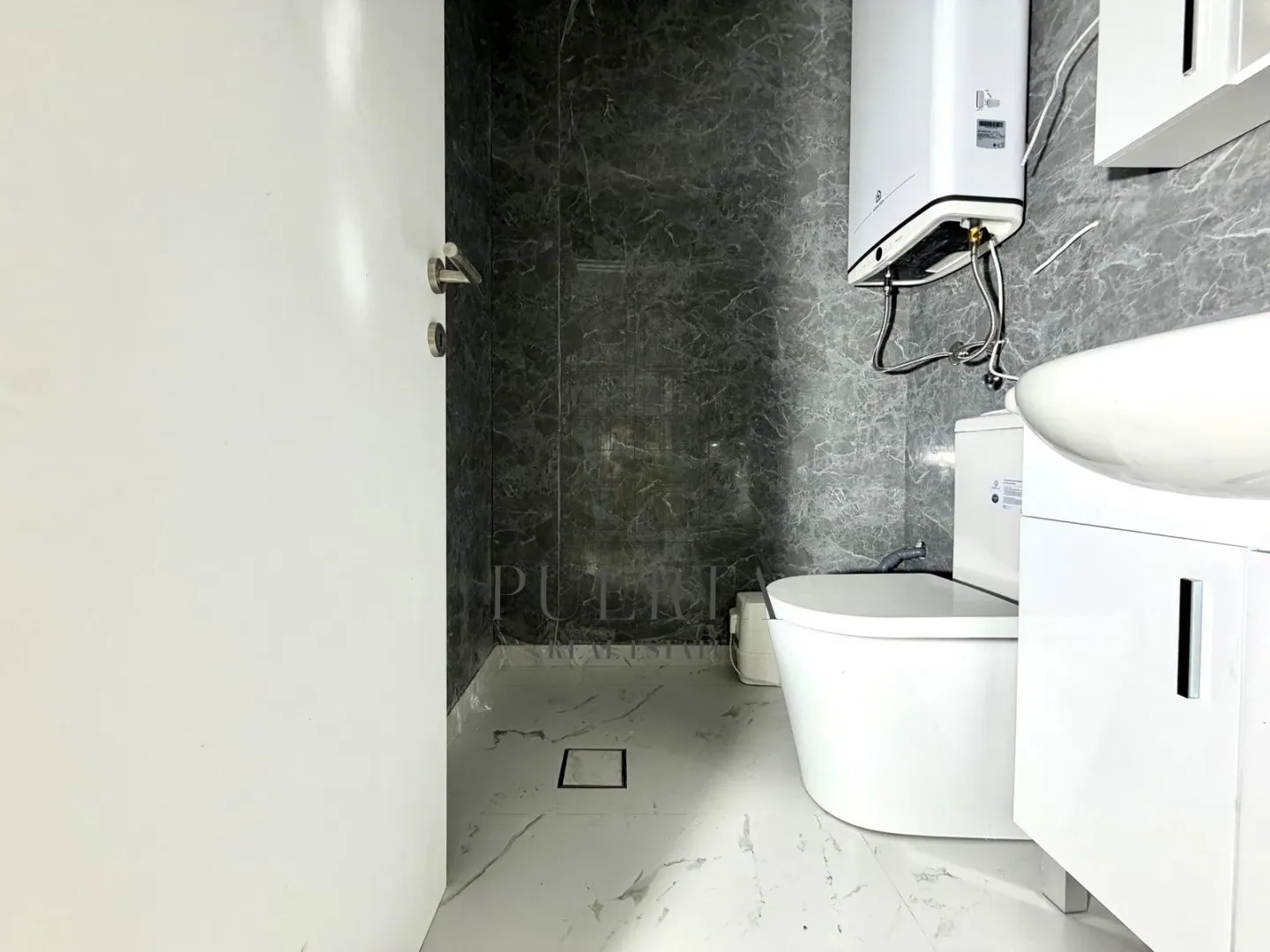 Small bathroom with white sanitary ware and grey marble tiles.