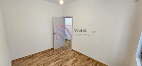 Prazna soba sa bijelim zidovima, drvenim podom i otvorenim vratima. - image 3