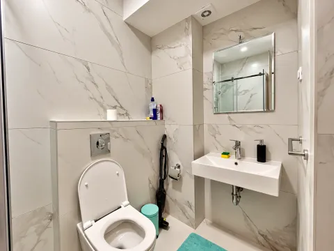 Modern bathroom with marble tiles and a wall-mounted toilet. - image 8