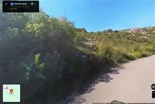 Pogled na plac i brdo pored puta sa Google Street View prikaza.