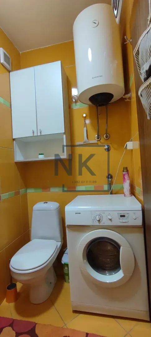Kupatilo sa wc šoljom, veš mašinom i bojlerom.