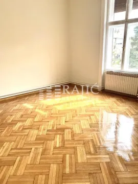 Empty room with parquet flooring and a large window. - image 12