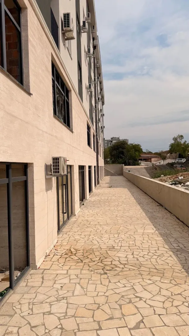 View of the paved terrace and the facade of the residential building.