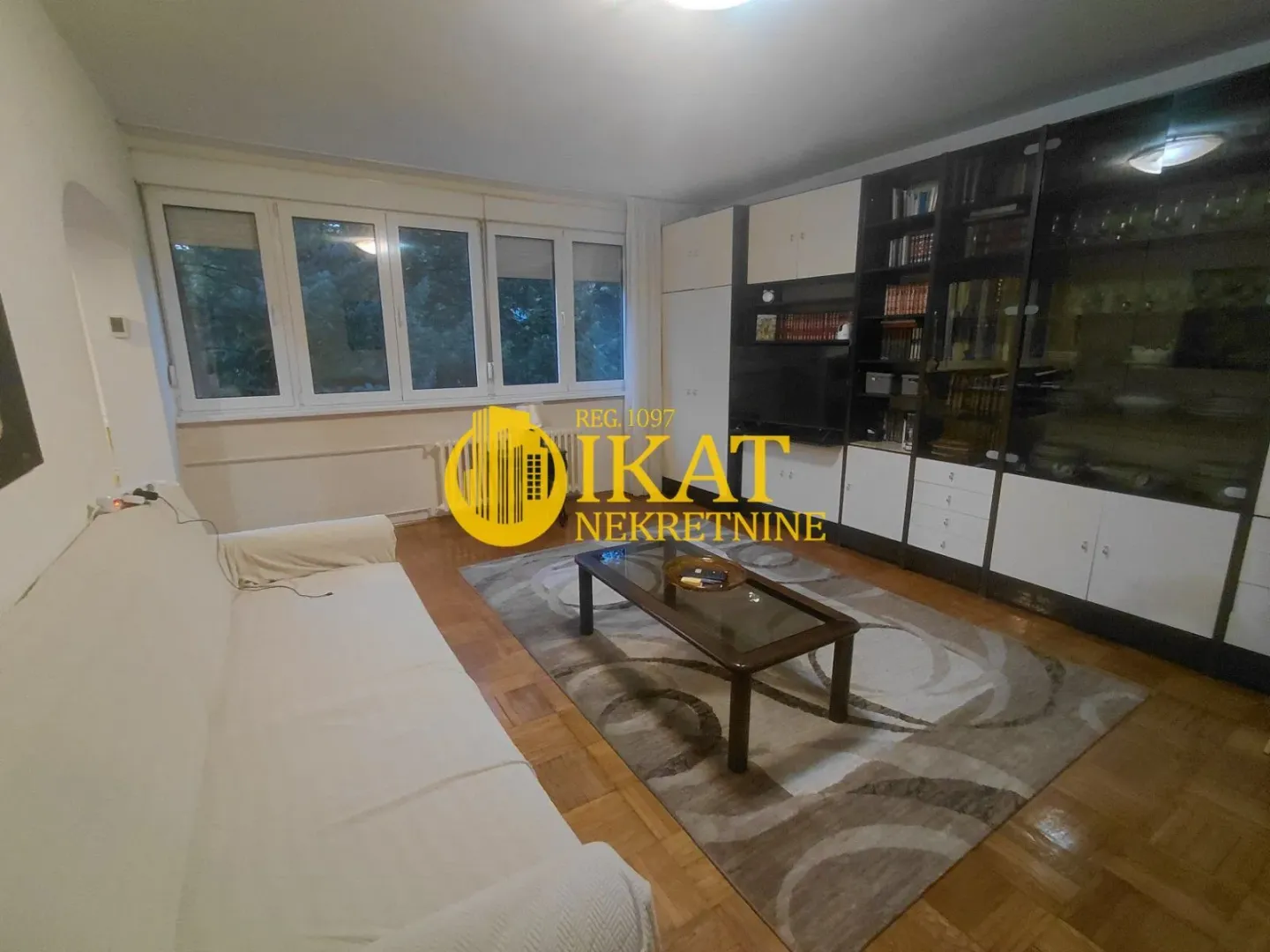 Living room with a sofa, coffee table, and a large wall unit with shelving.