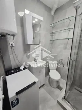 Modern bathroom with a shower cabin, washbasin, and washing machine. - image 11