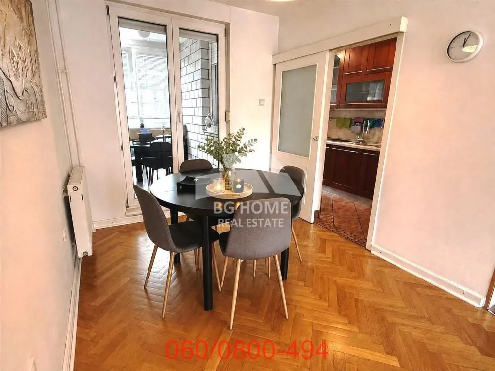 Dining area with a dining table and chairs, with a view of the kitchen and terrace.