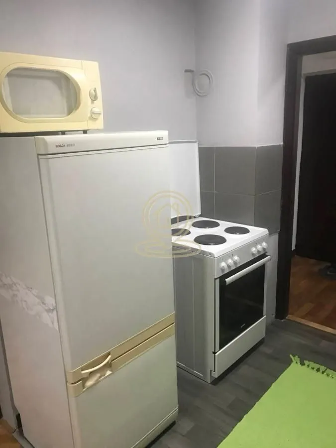 Manja kuhinja sa frižiderom, šporetom i mikrotalasnom pećnicom.