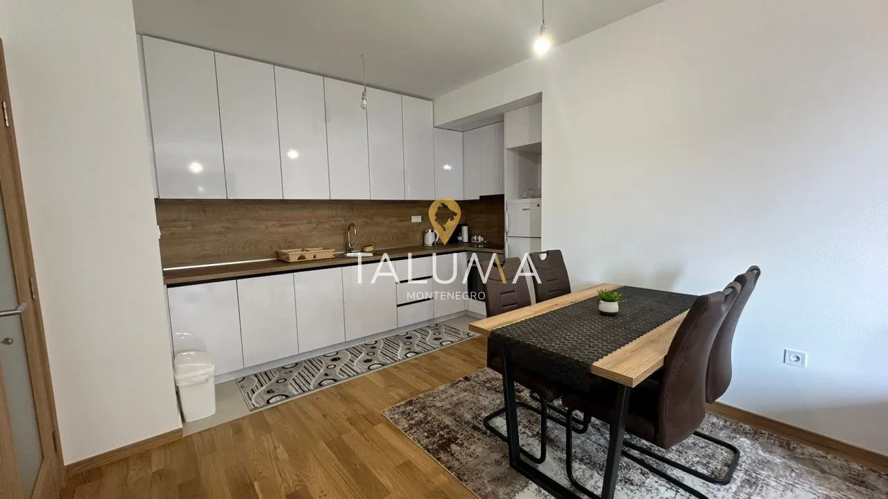 Modern kitchen with white cabinetry and a dining table.