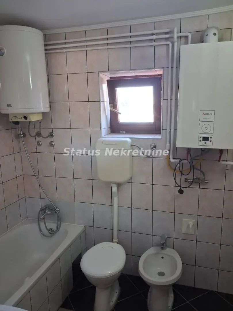 Bathroom equipped with a bathtub, toilet, bidet, and water heater.