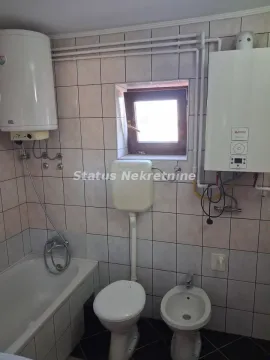 Bathroom equipped with a bathtub, toilet, bidet, and water heater. - image 15
