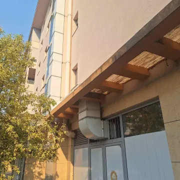 View of the exterior part of the residential building with an entrance and a wooden canopy. - image 4
