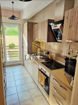 Moderna kuhinja sa drvenim elementima i izlazom na terasu. - image 8
