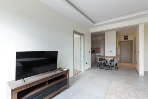 Living room with TV unit, dining area, and view of the kitchen. - image 11