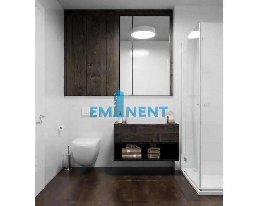 Modern bathroom with a shower cabin, wall-hung toilet, and a vanity with a mirror.