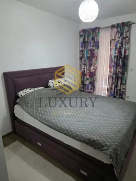 Bedroom with a double bed and a window with curtains. - image 3