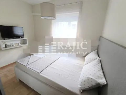 Furnished bedroom with a double bed and television. - image 4