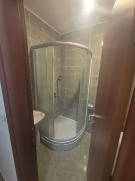 Pogled na manje kupatilo sa tuš kabinom i umivaonikom. - image 5