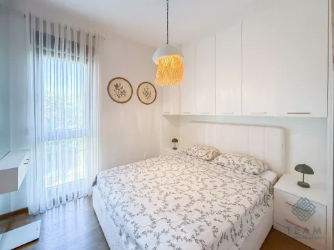 Modern bedroom with a double bed, built-in wardrobes, and a large window. - image 7