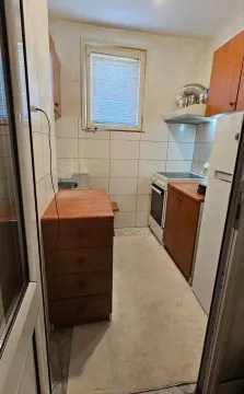 Manja kuhinja sa drvenim elementima, šporetom i frižiderom. - image 4
