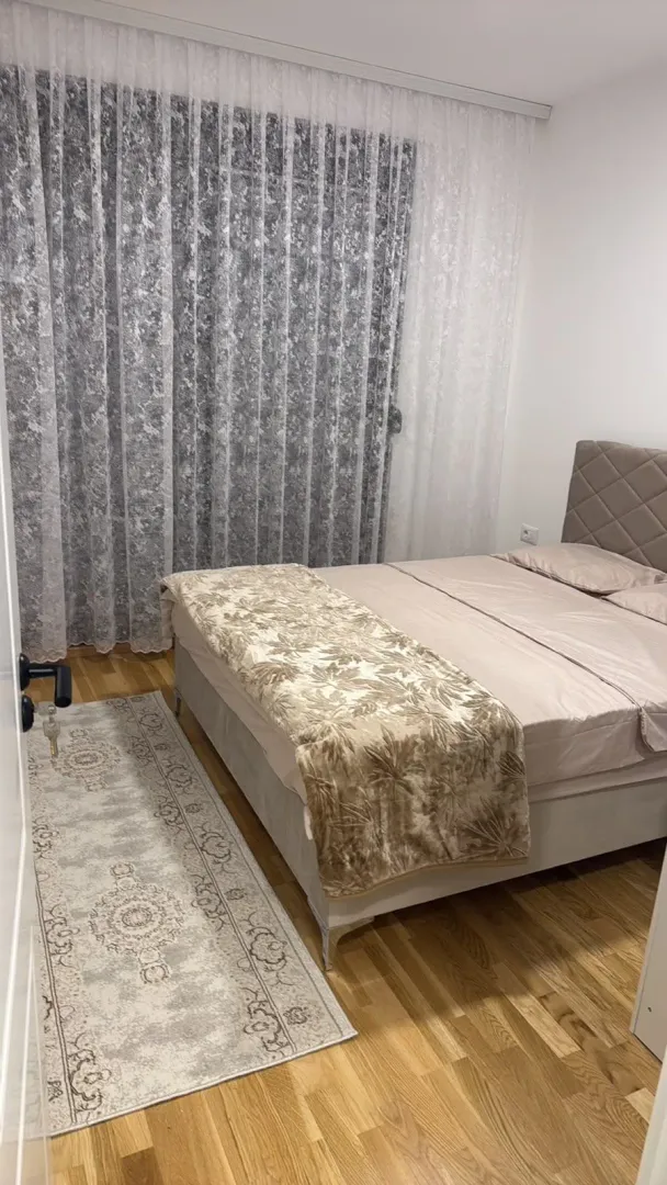 Tidied bedroom with a double bed and a window with curtains.