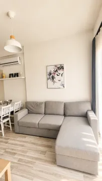 Living room with a sectional sofa, dining area, and air conditioning. - image 3