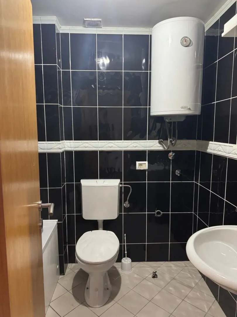 Small bathroom with black tiles and white sanitary ware.