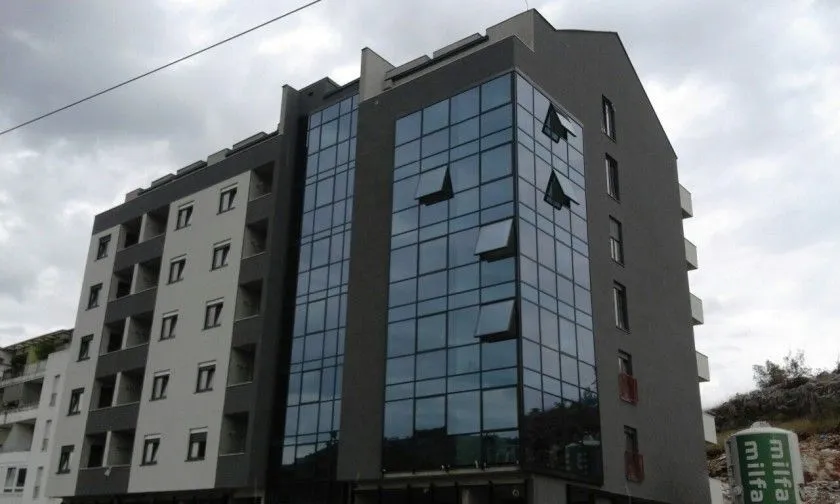 Exterior of a modern residential building with a glass facade.