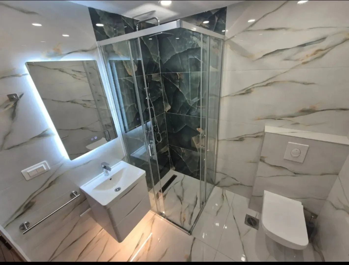 Modern bathroom with a shower cabin, washbasin, and built-in sanitary ware.