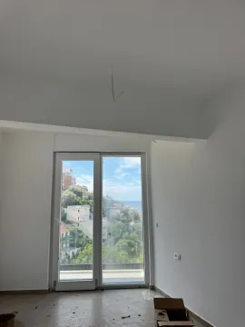 Empty room with white walls and balcony doors overlooking the sea. - image 10