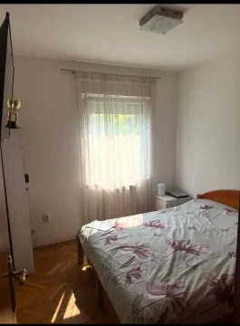 Manja spavaća soba sa bračnim krevetom, drvenim parketom i prozorom. - image 6