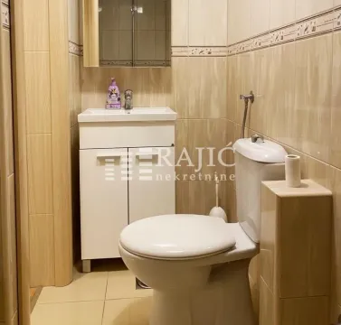 Smaller bathroom with a sink, toilet, and wall cabinet. - image 13