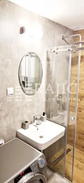 Modern bathroom with a sink, mirror, and walk-in shower. - image 9