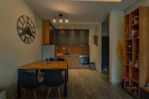 Modern kitchen with dining area and wooden furniture.