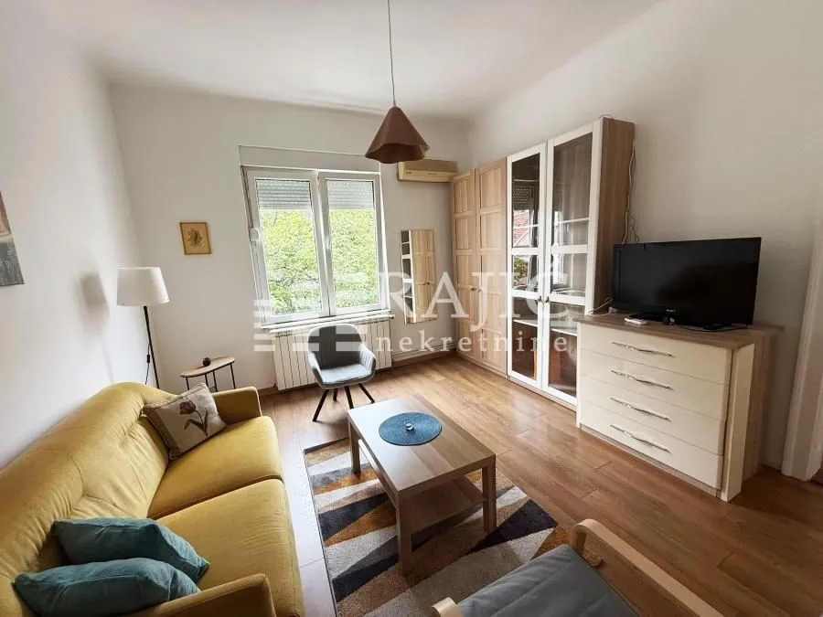 Living room with a sofa, TV stand, and wardrobe.