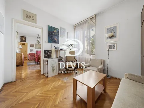 Dnevna soba sa drvenim parketom, garniturom i slikama na zidu. - image 9