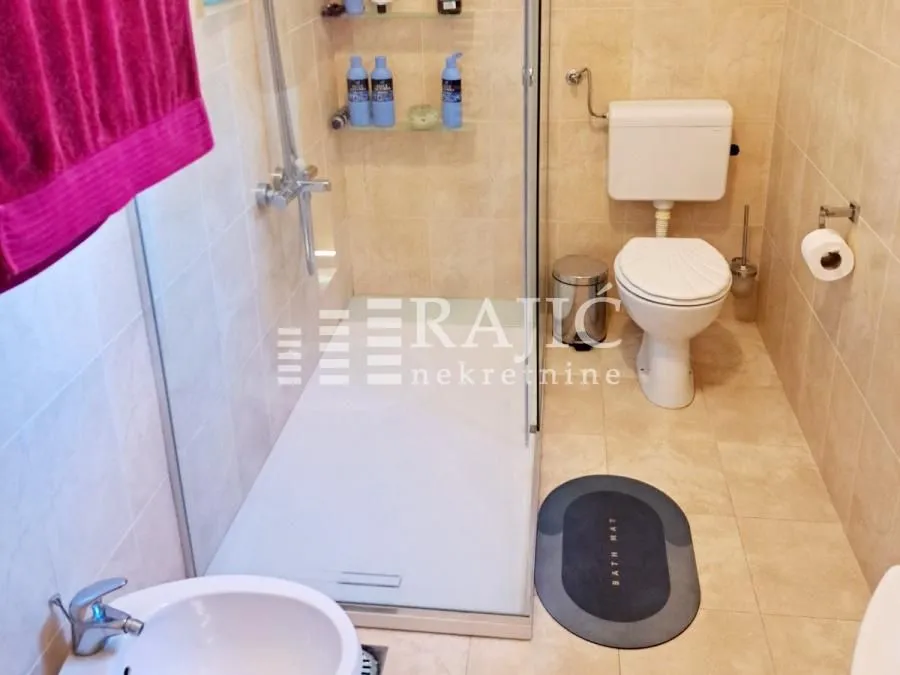 Smaller bathroom with a walk-in shower, toilet, and sink.