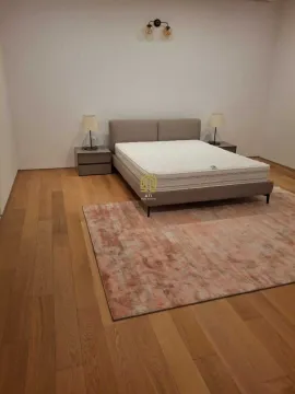 Spacious bedroom with a double bed, nightstands, and a rug. - image 7