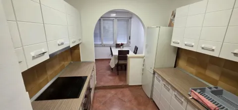 Kuhinja sa bijelim elementima i pogledom na trpezariju. - image 3
